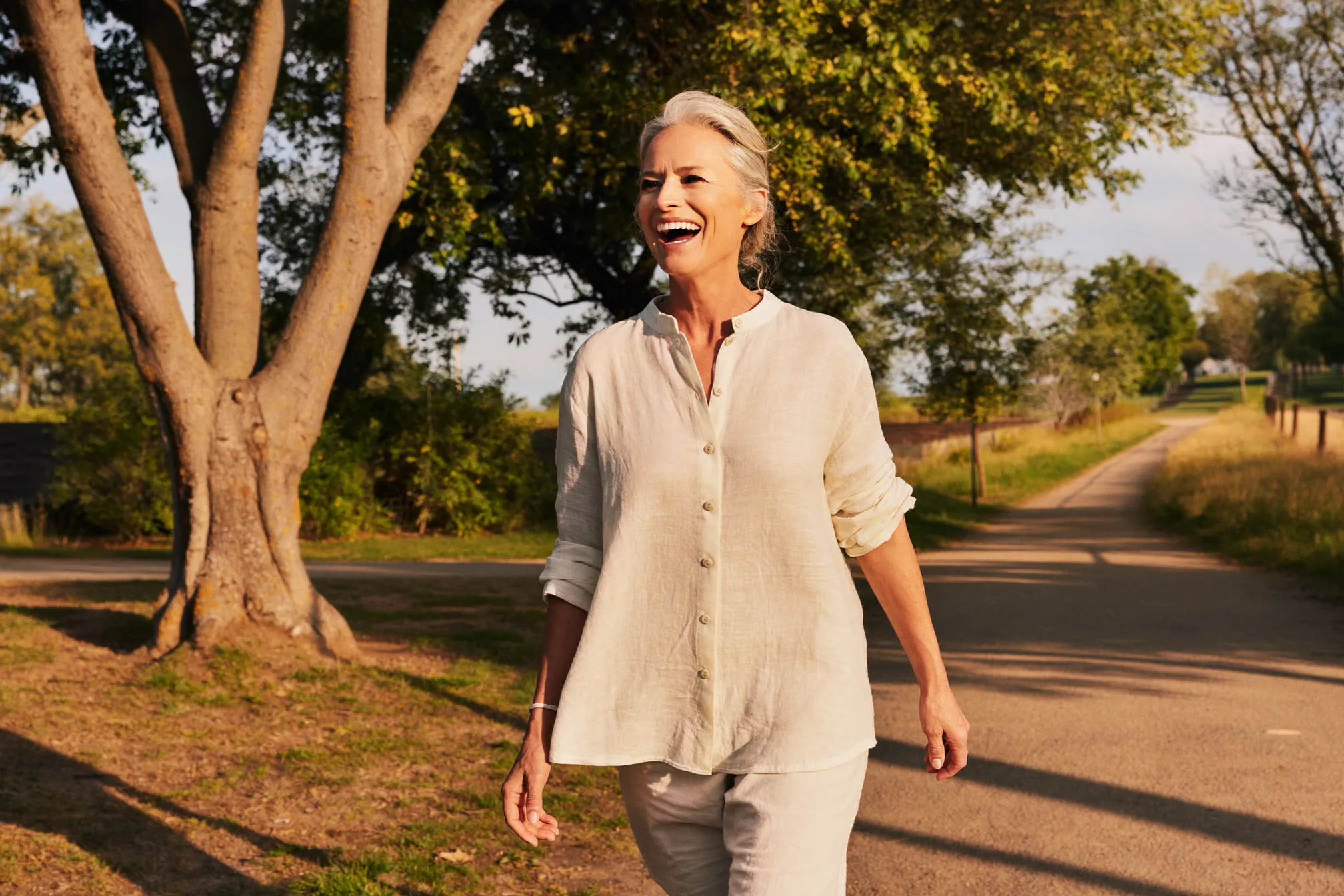 A vibrant woman walking outdoors in golden evening light